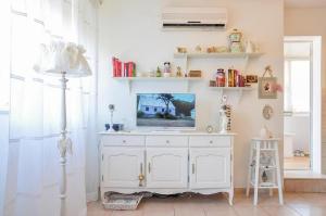 斯普利特内拉海滩公寓的一间客厅,在白色的橱柜上配有电视