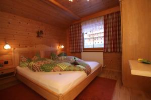 贝旺西巴赫豪斯酒店的木制客房内的一间卧室,配有一张床