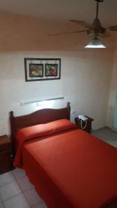 布宜诺斯艾利斯艾尔博特诺酒店的一间卧室配有红色的床和吊扇