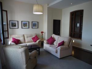 阿洛拉Apartamentos Candela Alora的客厅配有2张白色沙发和粉红色枕头