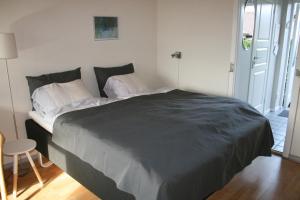 阿灵厄Hammerknuden的一间卧室配有一张大床和黑色毯子