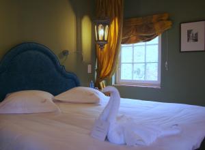 布鲁日运河豪华B＆B住宿加早餐酒店的一间卧室配有一张带白色床单的床和一扇窗户。