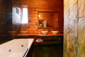 普孔阿尔迪诺卡纳波萨达精品旅馆的浴室设有2个水槽、浴缸和镜子