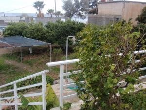 阿彻奇洛斯昂特昂玛缇纳公寓的一个带白色围栏和灌木的花园