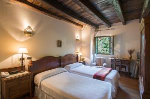 阿穆里奥卡塞里奥伊日尔里茨酒店的一间卧室设有两张床、一张桌子和一个窗口