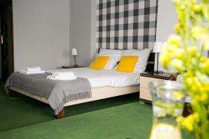 沃姆扎Labirynt的一间卧室配有一张带两个黄色枕头的床