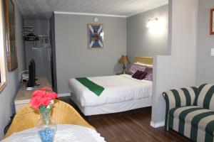 尼亚加拉瀑布尼亚加拉丽思汽车旅馆的一间卧室配有一张床和一张花瓶桌子