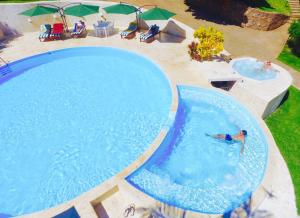 拉斯加勒拉斯Las Galeras Village Ecolodge的游泳池的顶部景色,游泳池里有一个男人