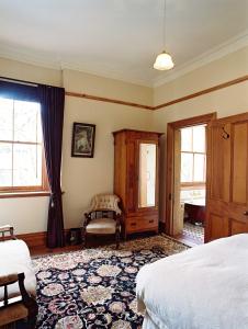 奥克兰布拉马尔议会大厦住所加早餐旅馆的一间卧室配有一张床、一把椅子和窗户。