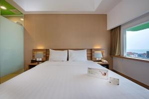 巴厘巴板巴厘巴板薇姿普瑞木酒店 的一张位于酒店客房的大床,设有窗户