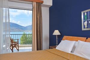哈尔基斯露西酒店的一间卧室设有一张床和一个享有美景的大窗户