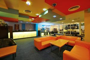 巴尔代约夫Hotel Šariš的一间配备有橙色沙发和桌子的等候室