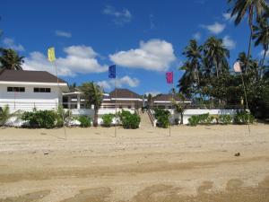 Libertad乌考海滩度假酒店的海滩上的房子,前面有旗帜