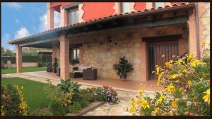 洛萨尔德拉韦拉Casa Rural La Canchalera的砖屋,带鲜花的庭院