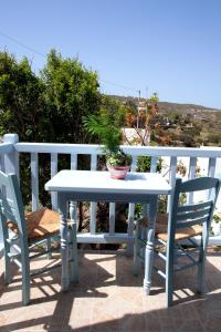 KámbosThea House Patmos的庭院里配有一张白色的桌子和两把椅子