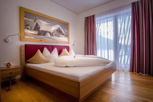 锡利安多洛米蒂-皇家公寓酒店的一间卧室设有一张大床和大窗户