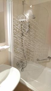 Objat法兰西酒店的浴室设有水龙头淋浴。