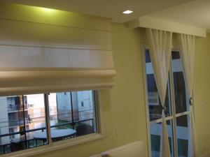 阿雷格里港Apartamento Aeroporto的客房设有带窗帘的窗户和阳台。