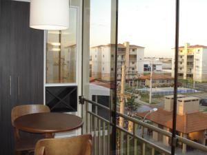 阿雷格里港Apartamento Aeroporto的市景阳台配有桌椅。