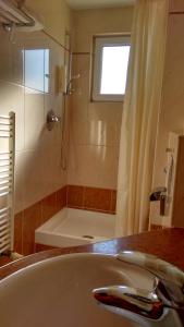 扎顿Aparthotel Lekavski的浴室配有水槽、淋浴和浴缸。