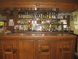 绍其德贝克Hotel Posada Andaluz的酒吧配有两把椅子和瓶装酒精饮品