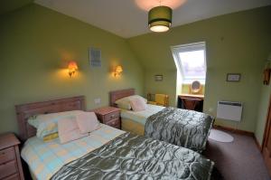 波特里Tarven Self Catering cottages的一间小卧室,配有两张床和窗户