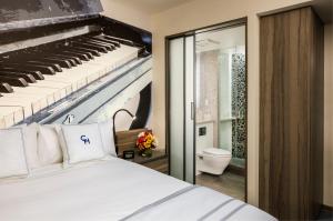 纽约卡内基酒店的卧室配有白色的床和大钢琴
