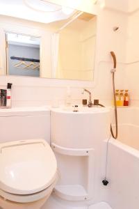 津市津西庭院豪华酒店的白色的浴室设有卫生间和水槽。