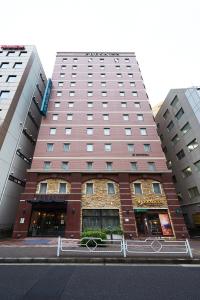 东京日本桥茅场町相铁Fresa Inn酒店的街道上一座高大的建筑,有两幢高大的建筑