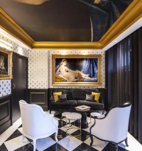 巴黎埃菲尔小卢浮宫酒店的客厅配有沙发和墙上的绘画