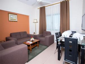 马斯喀特Safeer Plaza Hotel的客厅配有沙发和桌子