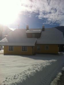 Jenig费瑞恩斯达斯维特酒店的屋顶上积雪的黄色房子