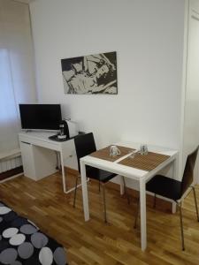 塞尔莫内塔B&B Stazione Latina的客房设有书桌和白色的桌椅。
