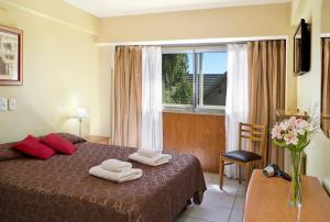 圣卡洛斯-德巴里洛切国际酒店的一间卧室配有带毛巾的床