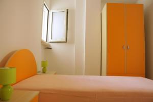 科尔萨诺Appartamento Roberti的一间卧室配有床和橙色橱柜