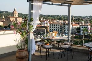 佛罗伦萨普林奇皮酒店的设有带桌椅的市景阳台。