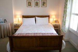 阿宾汉姆霍丽斯住宿加早餐旅馆的一间卧室配有一张带白色床单和两盏灯的床。