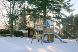 上哈茨山区舒伦贝格Haus Bambi的雪地中的游乐场,带滑梯