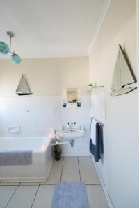 塔尔巴赫Tulbagh Travelers Lodge - Cape Dutch Quarters的白色的浴室设有浴缸和水槽。