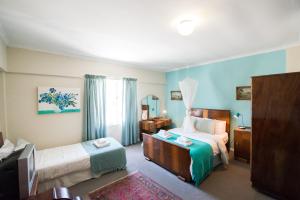 塔尔巴赫Tulbagh Travelers Lodge - Cape Dutch Quarters的酒店客房设有两张床和电视。