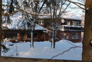 Manderfeld赫格罗特哲诺根床和早餐旅馆的一座房子,前面有树木,被雪覆盖着