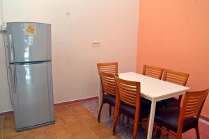 哥打巴鲁Homestay Kota Bharu, Telipot的一间带桌子和冰箱的用餐室