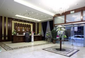 利雅德利雅得瑞士国际皇家酒店的站在酒店大厅的新娘和新郎