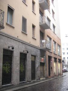 米兰Flat in Milan 1的街道边设有车库门的建筑