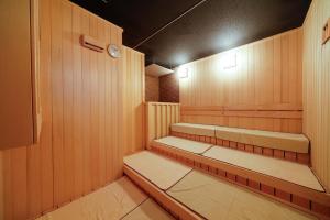 富山多美迎富山酒店的一间室内带长椅和时钟的桑拿浴室