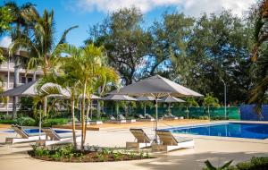 努库阿洛法塔诺阿国际日期变更线酒店 的一个带椅子和遮阳伞的度假游泳池