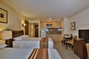 麦克坦麦克坦皇冠丽晶套房酒店的酒店客房带两张床和厨房