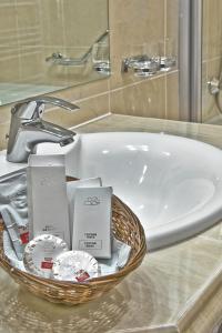 布拉索夫Hotel Citrin - Adults Only的浴室水槽和洗浴用品篮