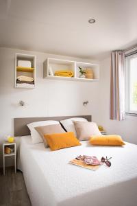 奥尔贝泰洛Giannella Camping的卧室配有带橙色枕头的大型白色床