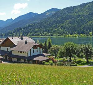 魏森湖菲里恩霍夫奥博加瑟尔贝格布里克酒店的一座大房子,后面有湖泊和山脉